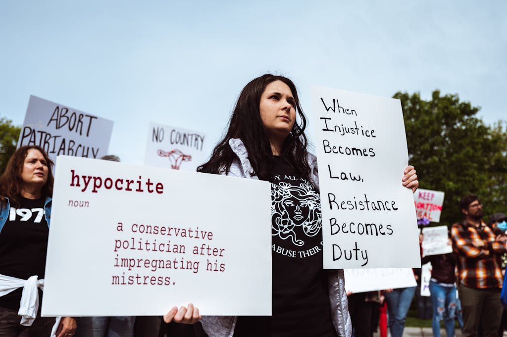A group of protesters advocating for social justice and gender equality with impactful signs.